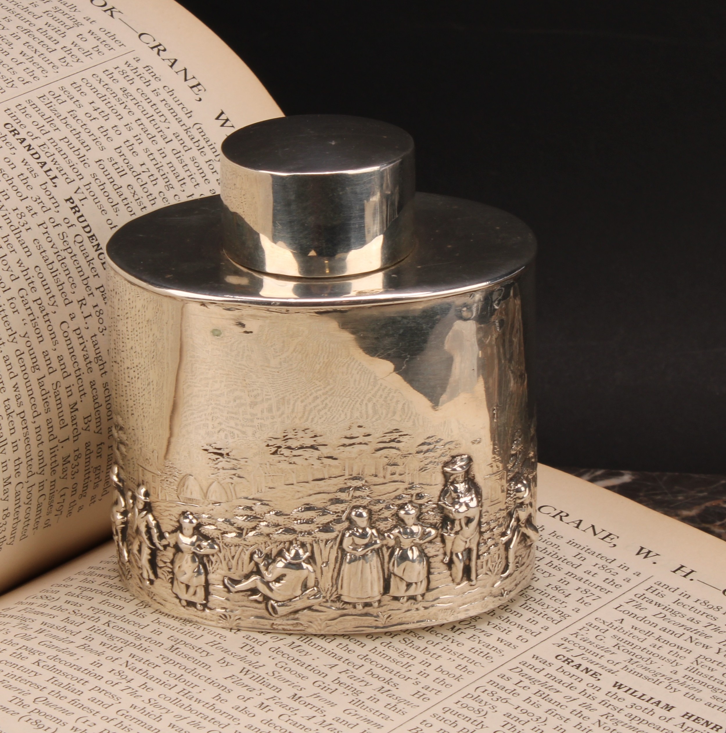 An Edwardian silver oval tea caddy, chased in the Teniers taste, push-fitting cover, 8.5cm wide,