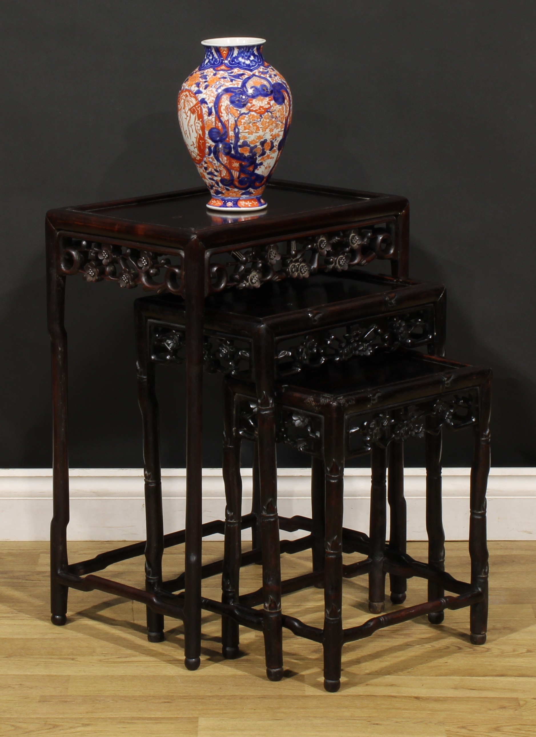 A Chinese hardwood harlequin nest of three occasional tables, each with a rectangular panel top,