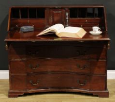 An unusual George III mahogany bureau, fall front enclosing a small door, small drawers, pigeonholes