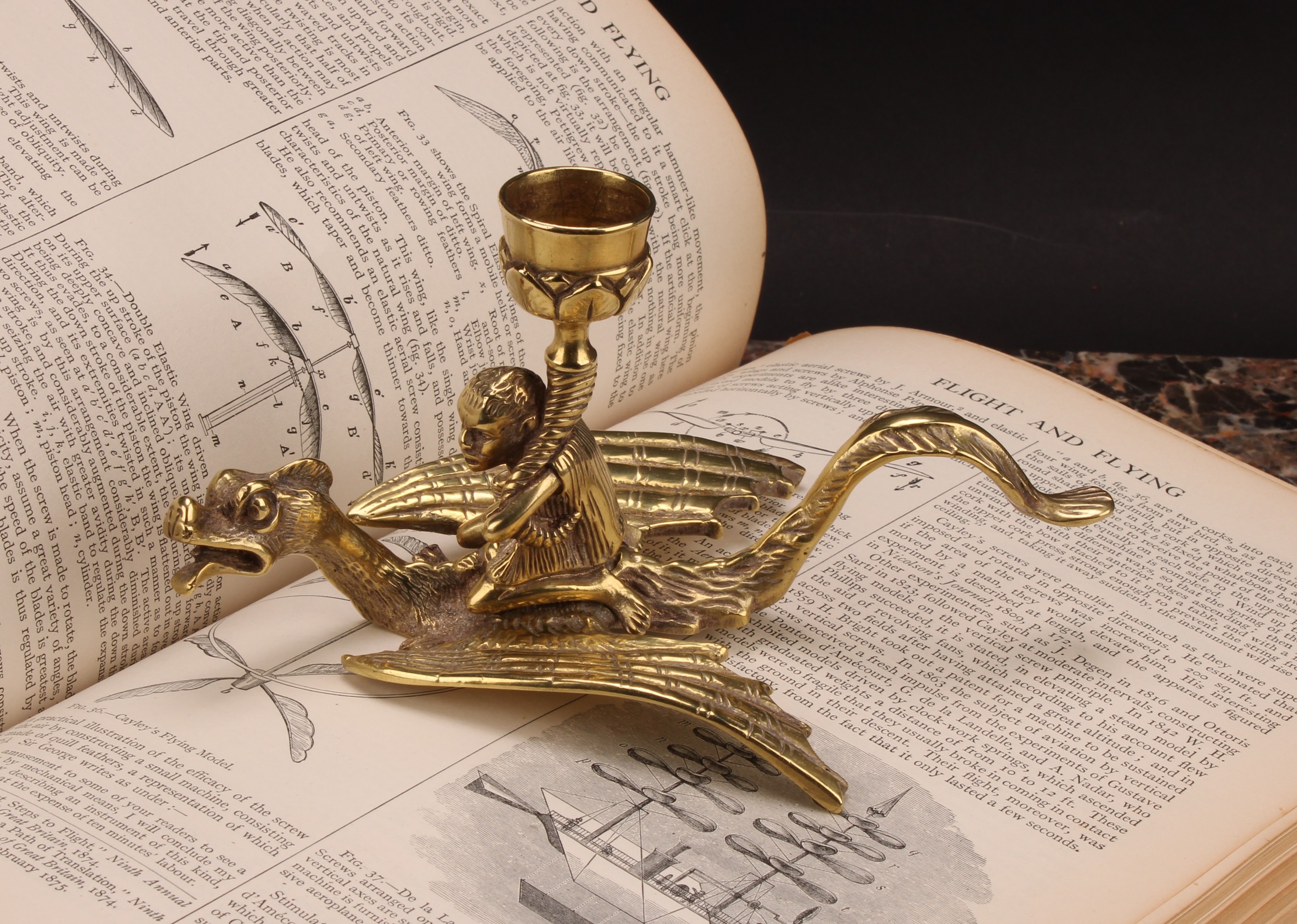 A 19th century brass chamberstick, cast as a figure riding a dragon, 9cm high