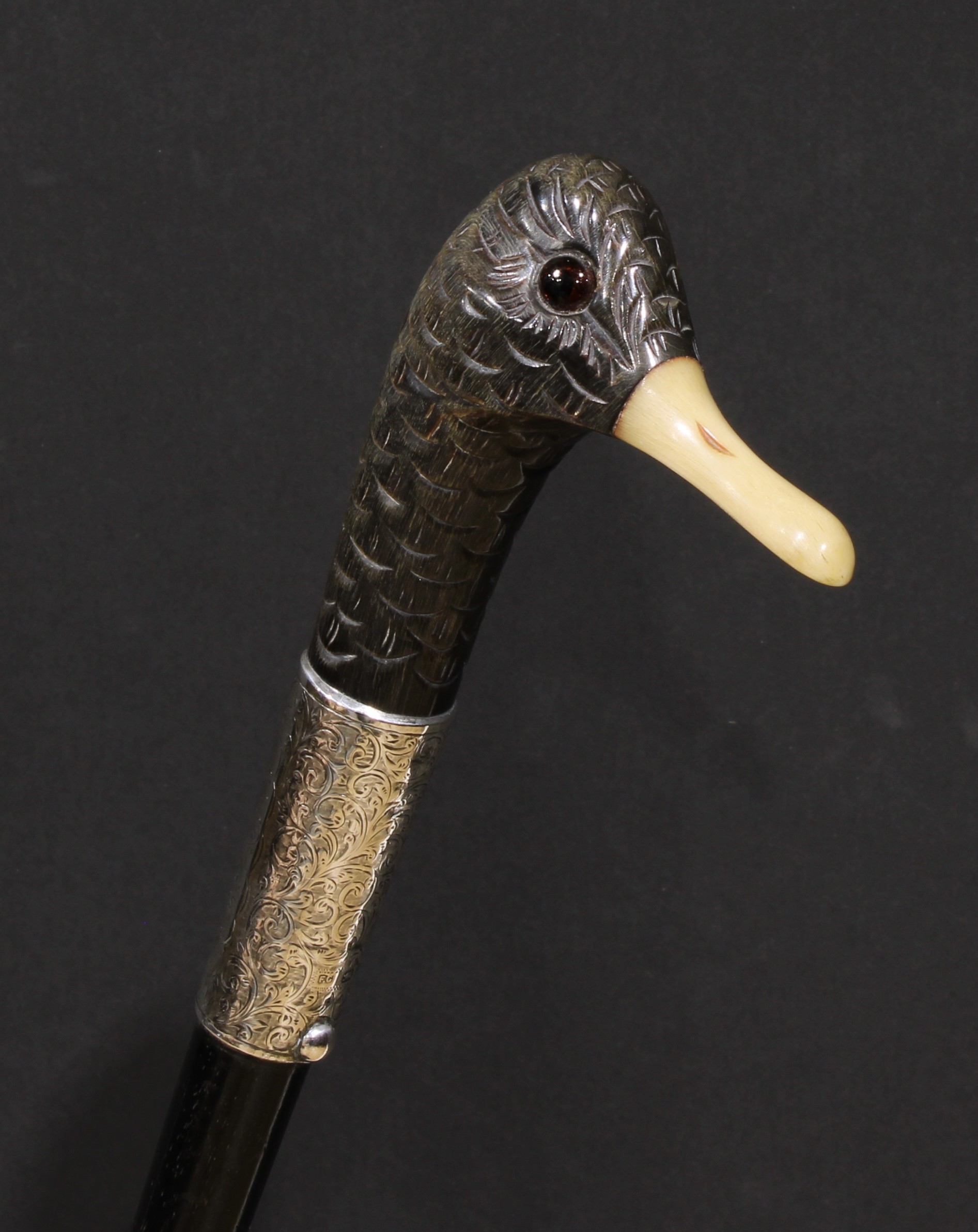 A Victorian silver mounted novelty walking stick, the horn handle carved and stained as the head