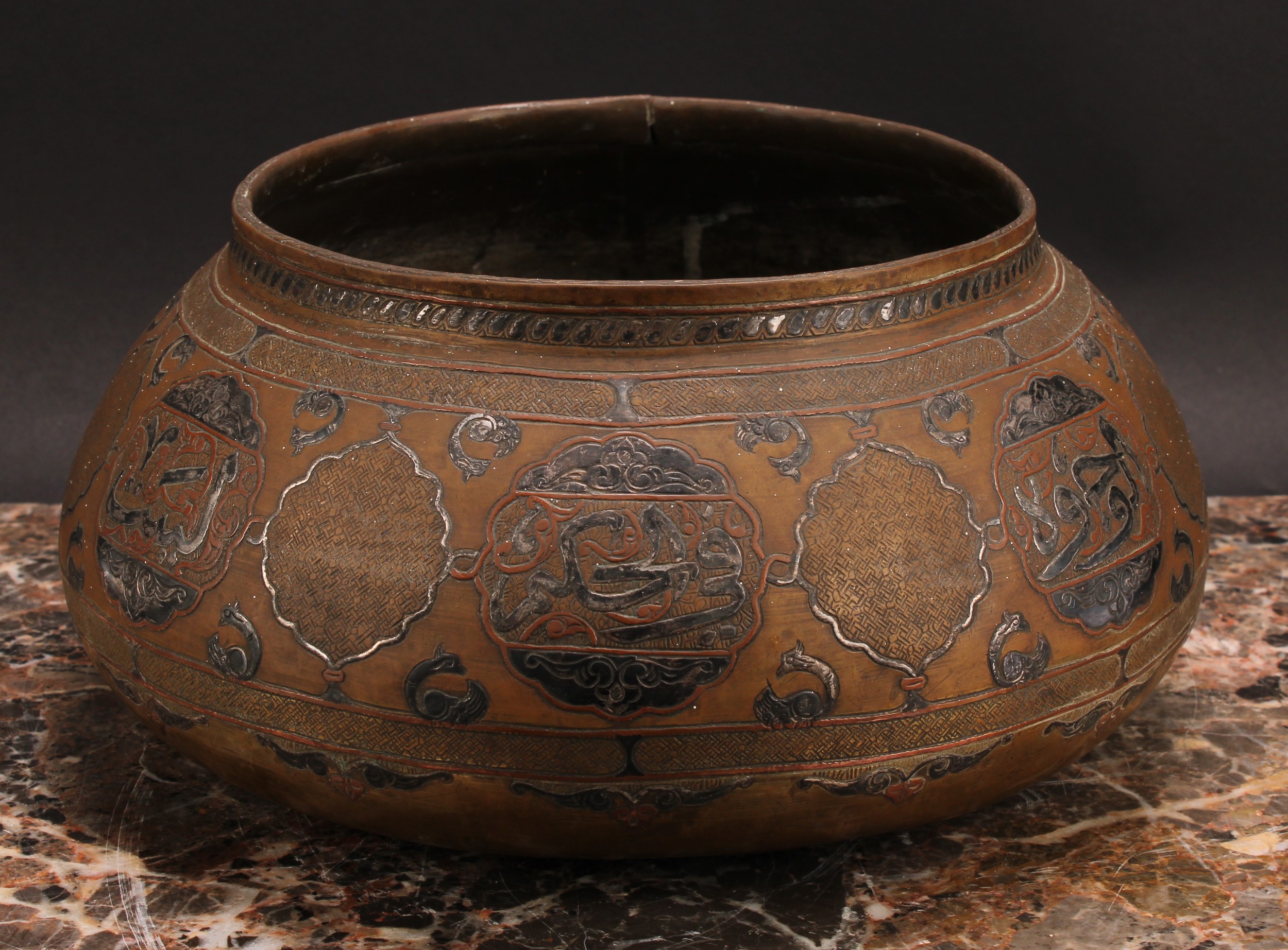 A Middle Eastern silver and copper damascened brass bowl, decorated in the Islamic taste with
