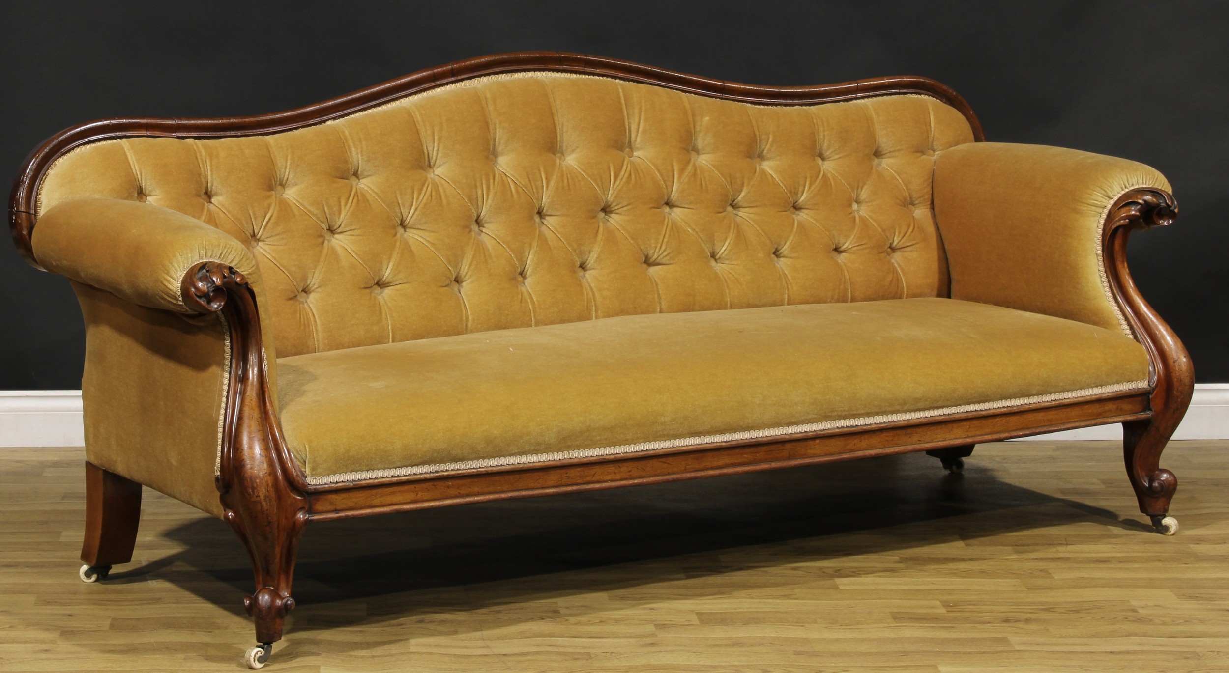 A Victorian mahogany sofa, serpentine cresting rail, stuffed-over upholstery, the arms carved with - Image 2 of 2