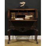 A French provincial Régence Revival oak bureau, fall front enclosing small drawers and