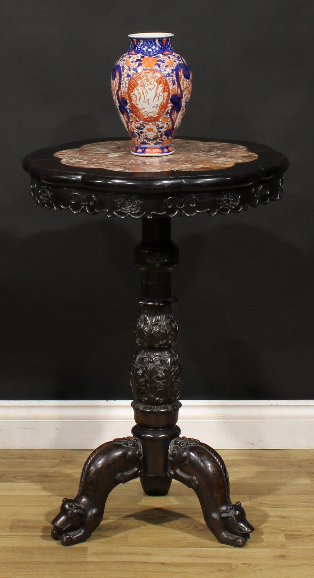 A Chinese hardwood tripod porcelain table, octofoil top with inset marble panel, turned column