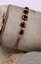 A garnet and diamond bracelet, the five graduated rectangualr mixed cut garnets divided by pairs