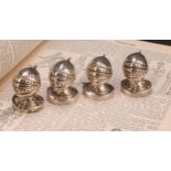 A set of four Victorian Gothic Revival silver novelty peppers, each as a knight's helmet and