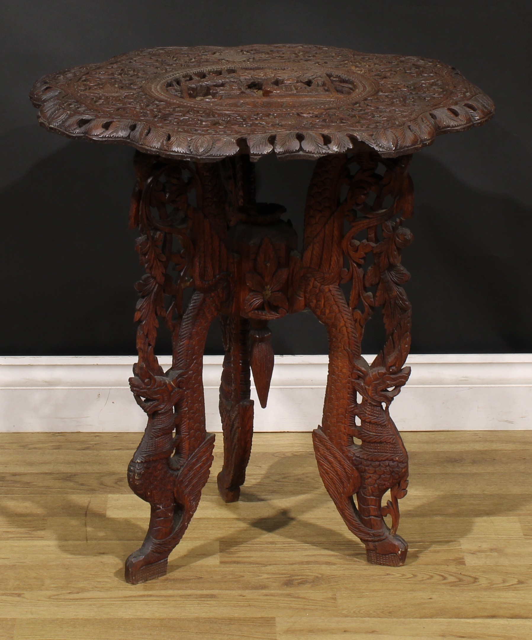 An Anglo-Indian hardwood occasional table, shaped circular top carved with deities within a band