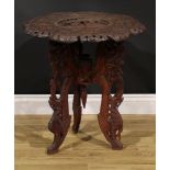 An Anglo-Indian hardwood occasional table, shaped circular top carved with deities within a band