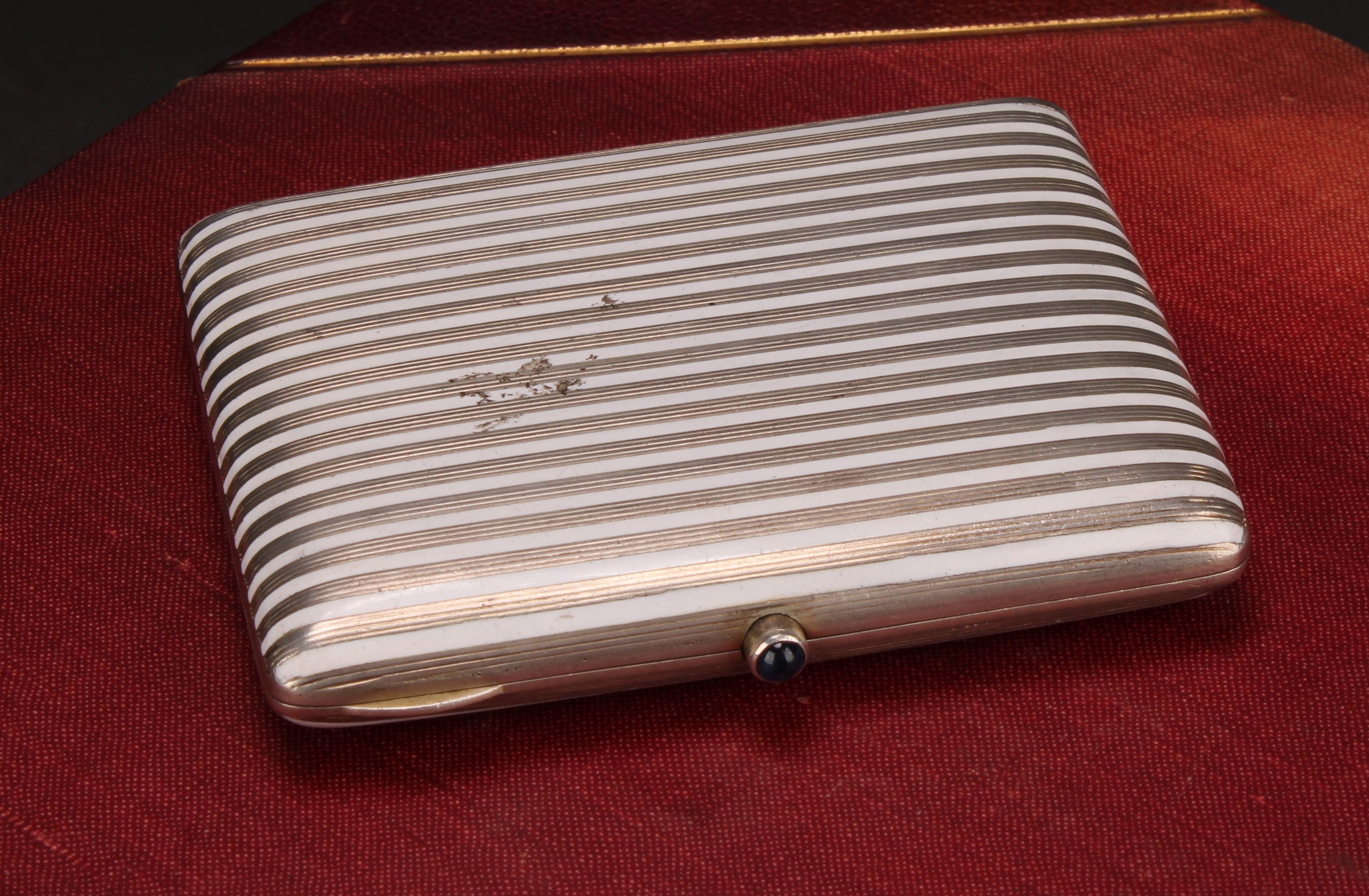 A Continental silver and enamel rounded rectangular cigarette case, banded in white, hinged cover,