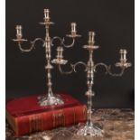 A pair of George II cast silver table candlesticks, fitted with Victorian three-light candelabra