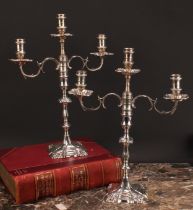 A pair of George II cast silver table candlesticks, fitted with Victorian three-light candelabra
