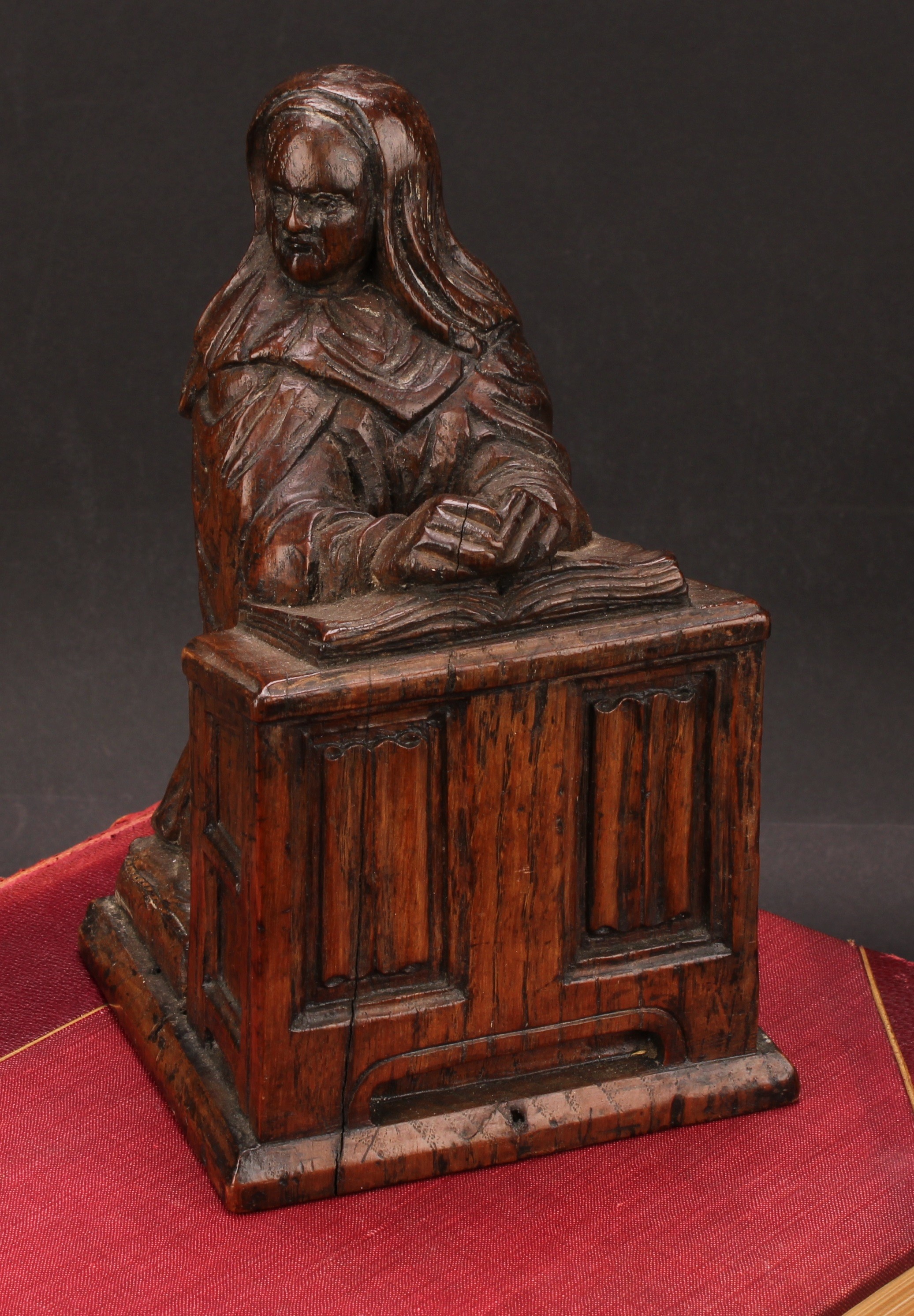 A 19th century carved oak figure, of Saint Rita of Cascia, kneeling in prayer at a prie-dieu, 18.5cm