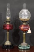 A late Victorian/Edwardian oil lamp, Duplex burner, facetted cranberry glass font, brass column