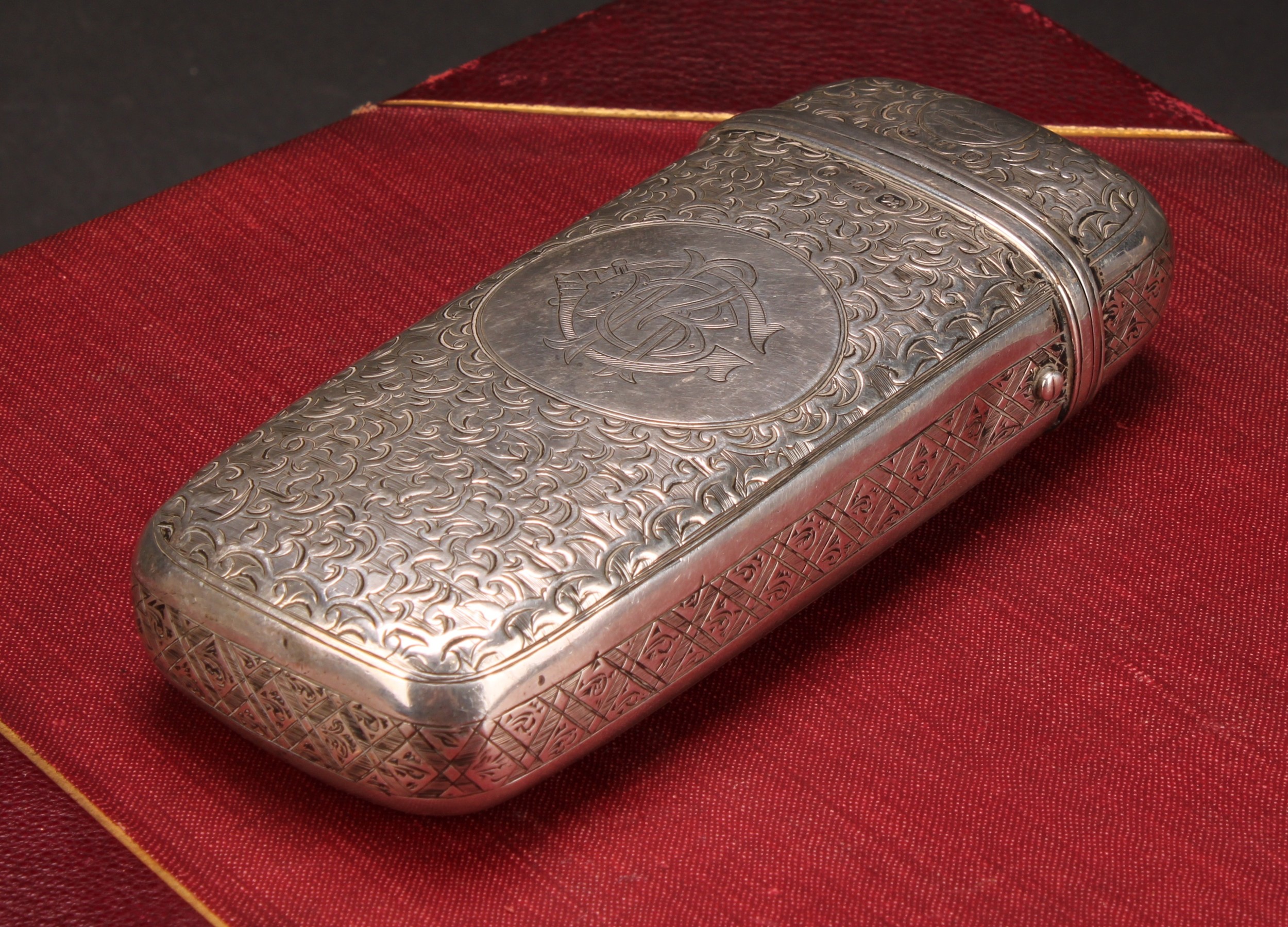 A Victorian silver rounded rectangular cigar or cheroot case, profusely engraved with scrolling