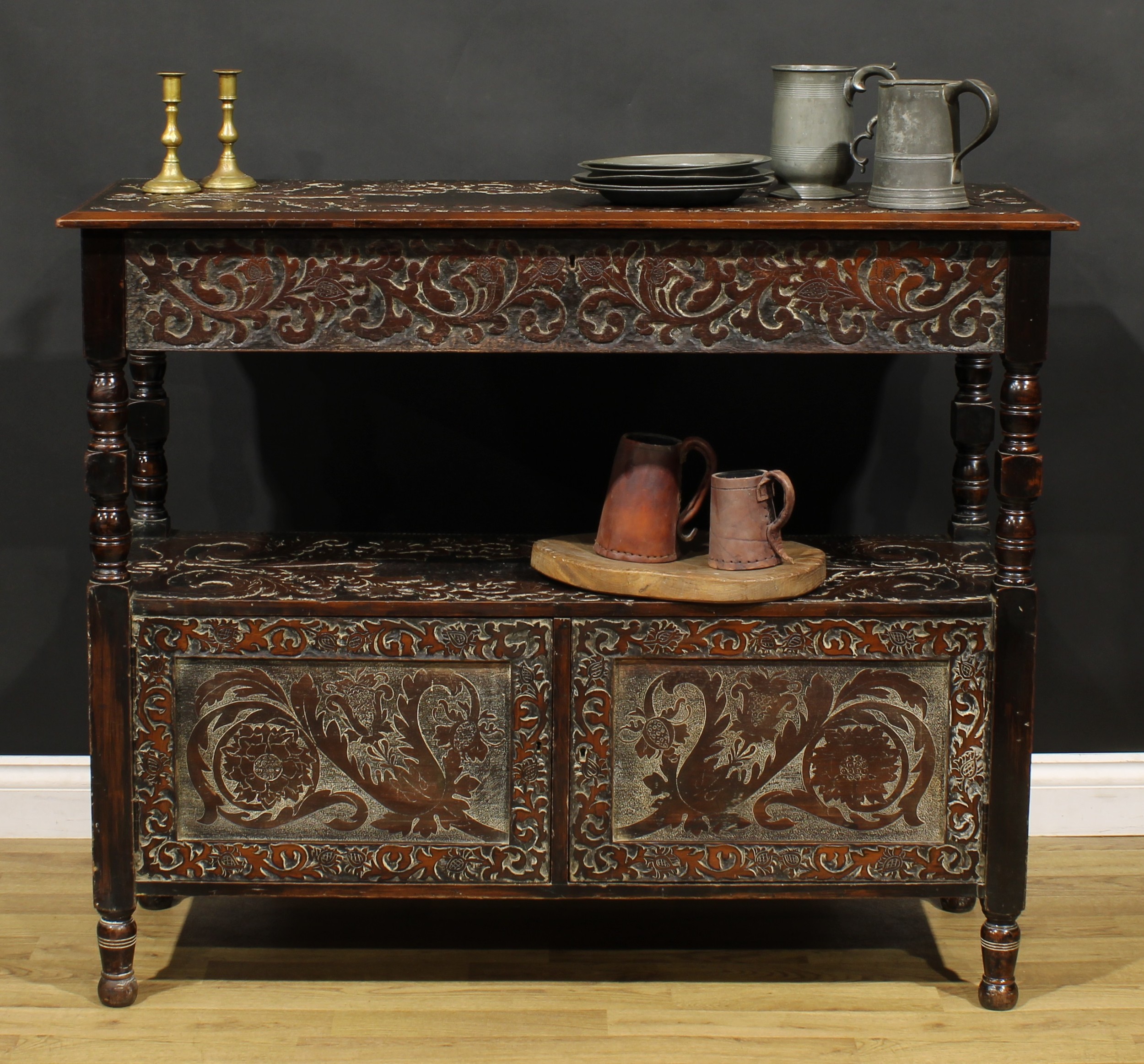 An Arts & Crafts period two-tier buffet serving table, drawer to frieze, doors to base, carved