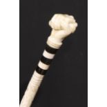 A 19th century sailor's maritime whale bone walking stick, the pommel carved as a fist grasping a