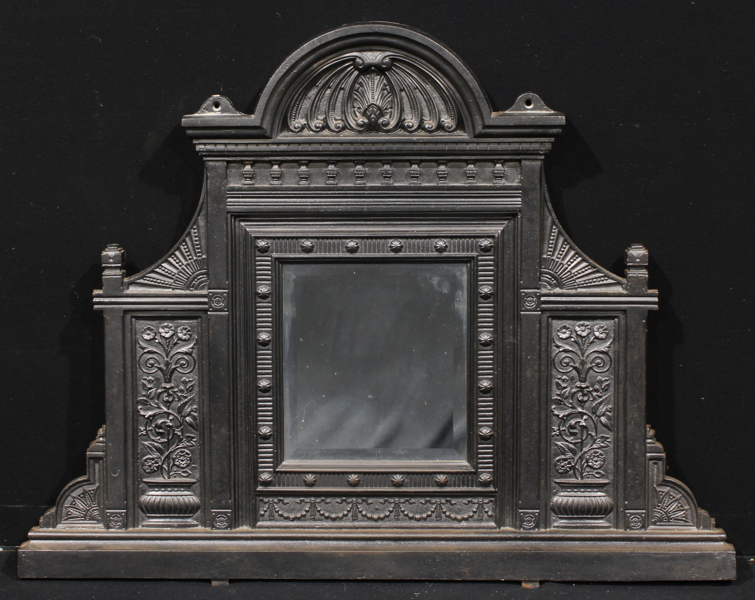 A Victorian cast iron chimney glass, arched cresting above a bevelled mirror plate, 91cm high, 118cm