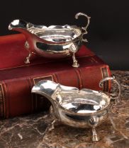 A pair of George III silver sauce boats, acanthus-capped flying scroll handles, wavy borders, hoof