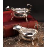 A pair of George III silver sauce boats, acanthus-capped flying scroll handles, wavy borders, hoof