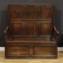 An 18th century oak box settle, rectangular panel back, hinged seat, 147cm high, 140cm wide, the