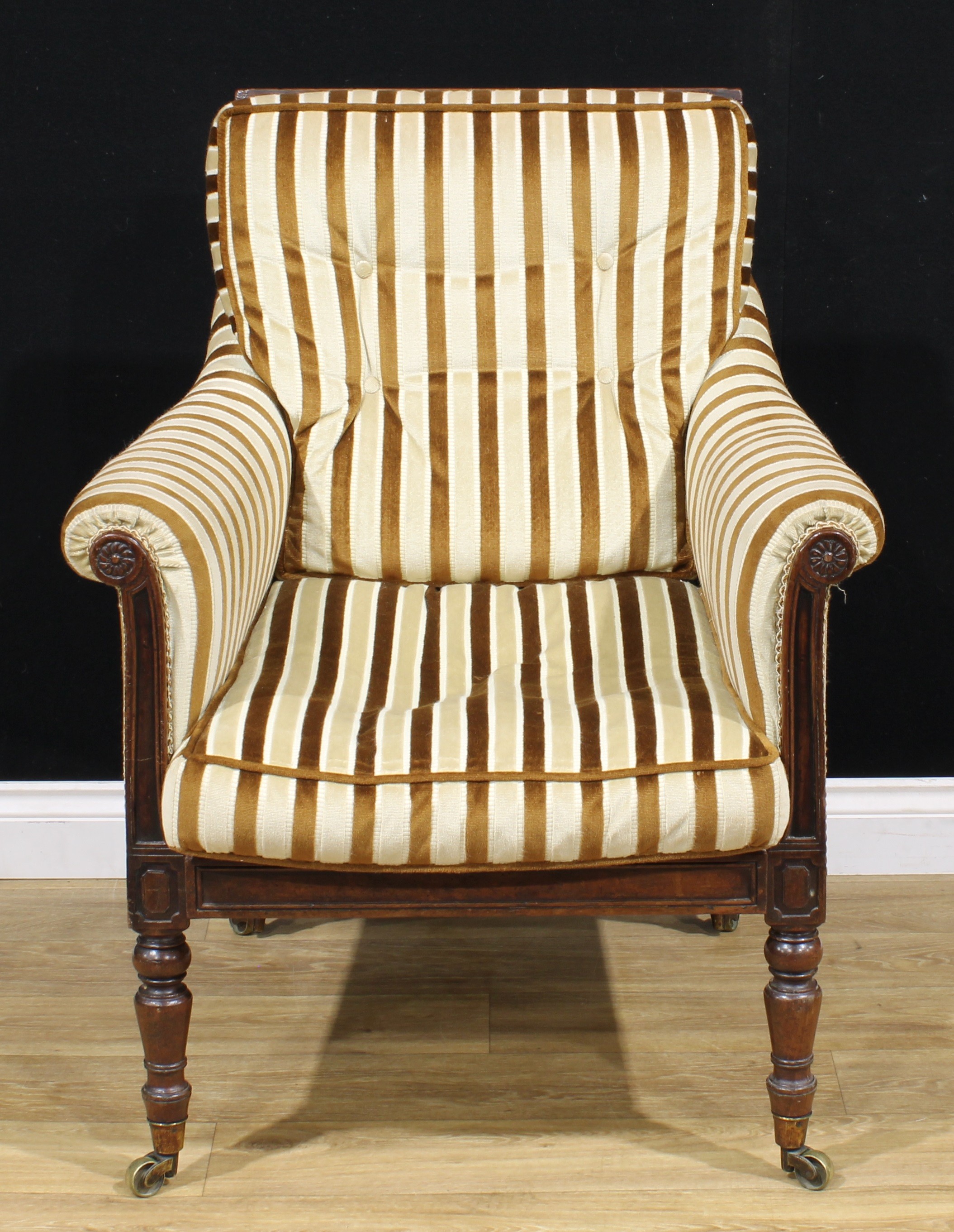 A George IV mahogany library chair, cane back, stuffed-over upholstery, turned forelegs, brass