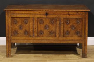 An 18th century oak blanket chest, hinged top enclosing a till above a three panel front, carved