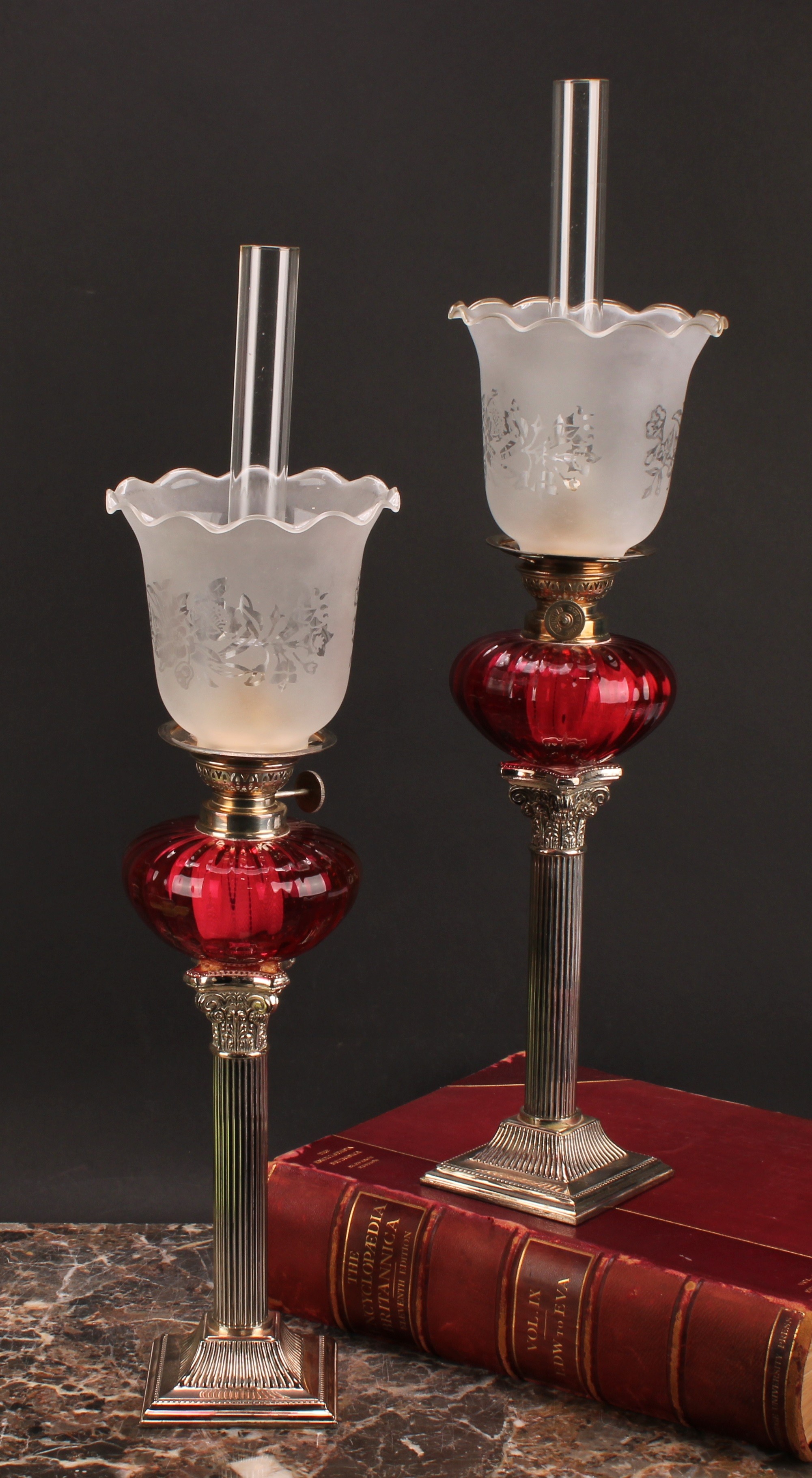 A pair of EPNS Corinthian column table oil lamps, frilled shades, fluted glass reservoirs, 54cm high