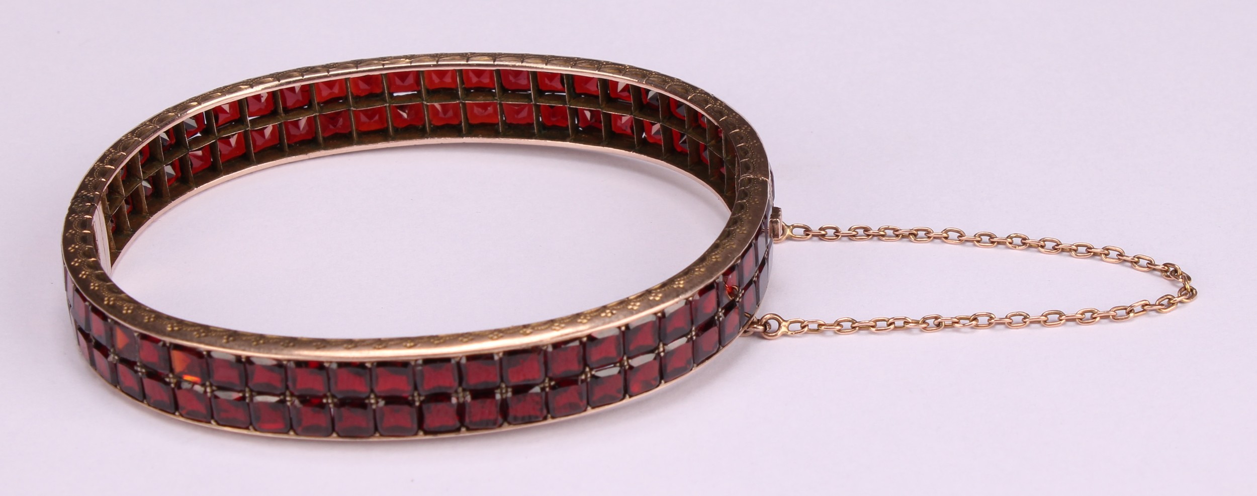 A continental gold bangle, applied with a double row of asscher cut channel set garnets, the - Image 2 of 5