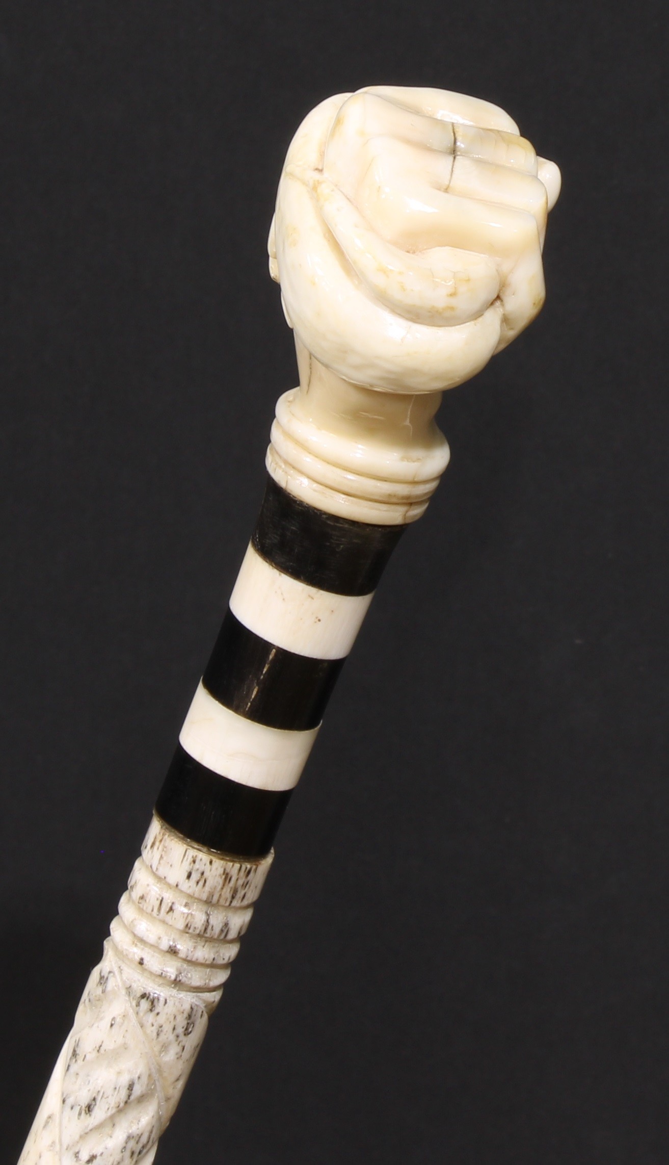 A 19th century sailor's maritime whale bone walking stick, the pommel carved as a fist grasping a - Image 2 of 4