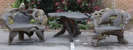 An Indonesian teak rootwood tête-à-tête garden suite, comprising table and a pair of chairs, the