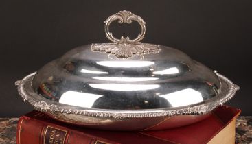 A George III silver oval vegetable dish, ogee cover with leafy loop handle, enclosing a detachable