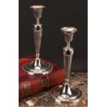 A pair of George III Neo-Classical silver table candlesticks, in the Adam taste, detachable nozzles,