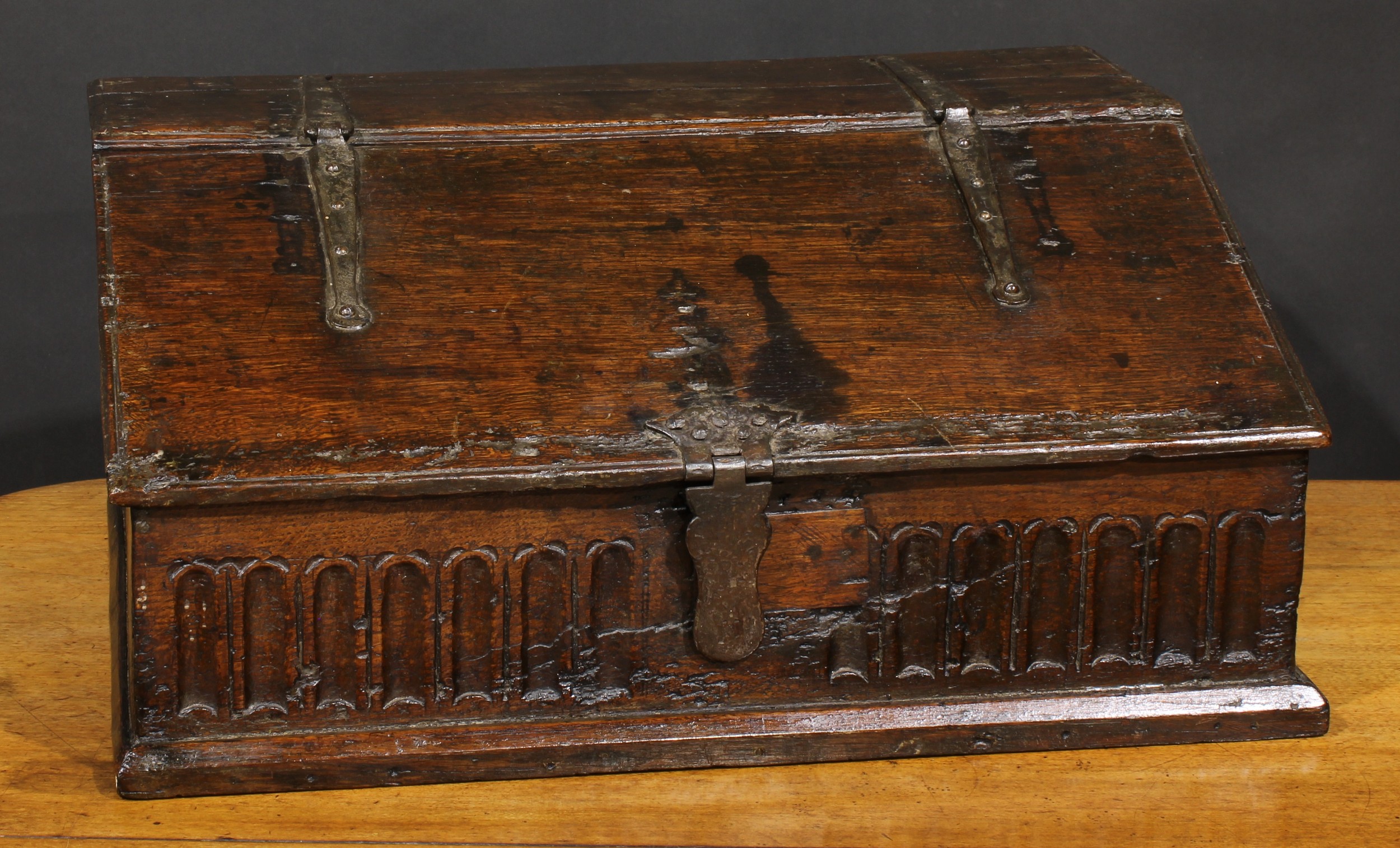 An 18th century oak boarded table box, hinged sloping top above a nulled frieze, 29cm high, 63.5cm