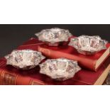 A set of four Victorian silver shaped circular sweetmeat dishes, pierced and embossed with shells,