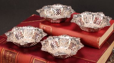 A set of four Victorian silver shaped circular sweetmeat dishes, pierced and embossed with shells,