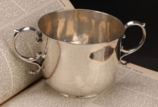 A William & Mary silver porringer, quite plain, scroll handles, 17cm wide, maker CK, London 1688,