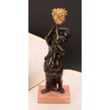 A 19th century patinated bronze, of a putto, holding aloft a gilt metal flower, rectangular rouge