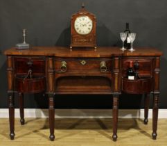 An unusual Regency mahogany sideboard or serving table, slightly oversailing top above a central