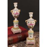 A pair of Berlin porcelain cassolettes, each as a pedestal urn on column support, stepped square