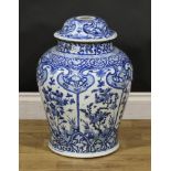 A Chinese baluster temple jar and cover, decorated in tones of underglaze blue with panels of