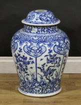 A Chinese baluster temple jar and cover, decorated in tones of underglaze blue with panels of