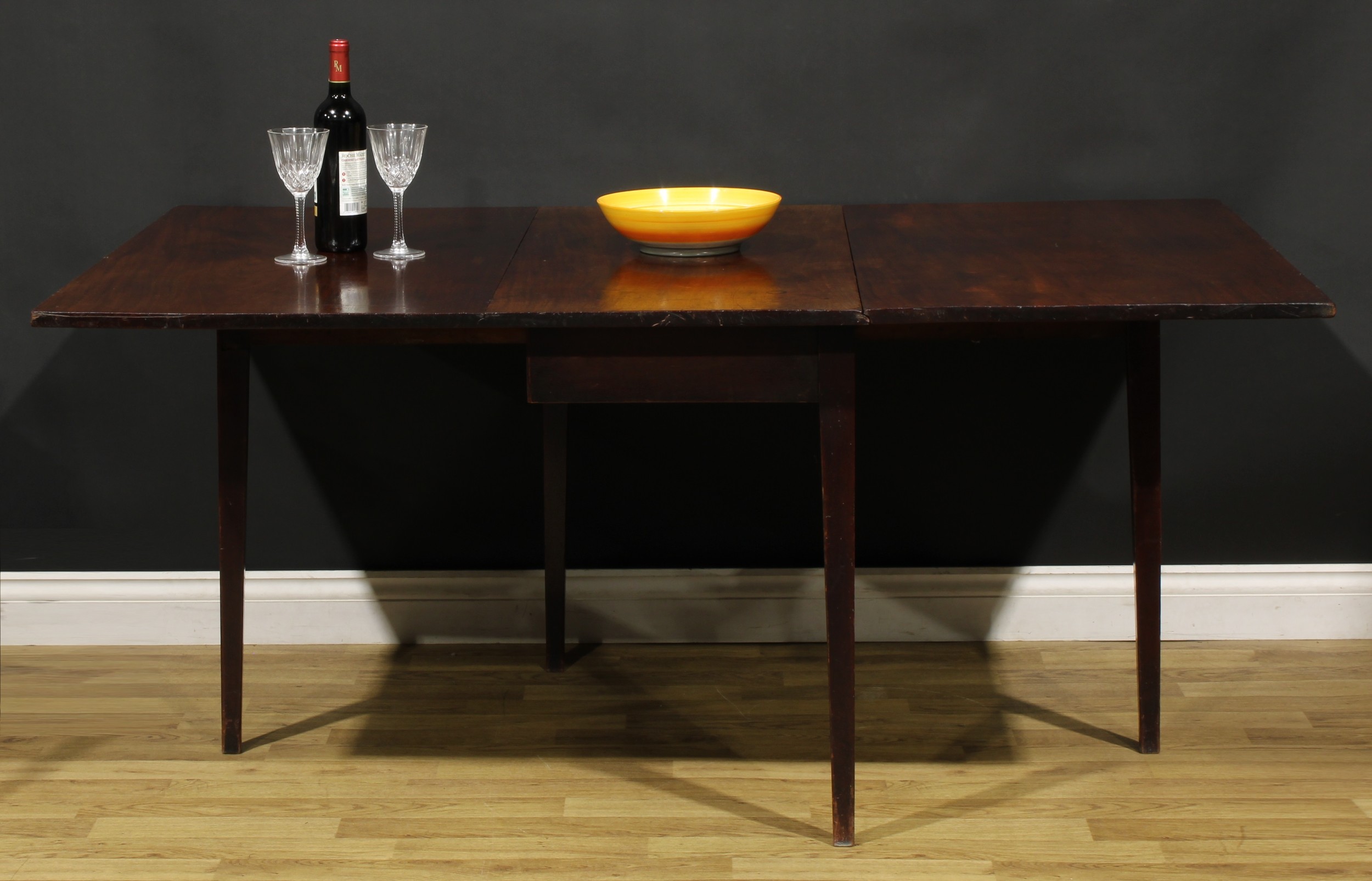 A George III mahogany gateleg dining table, rectangular top with fall leaves, tapered square legs,