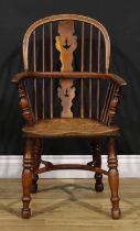 A 19th century yew and elm child’s Windsor elbow chair, low hooped back, shaped and pierced splat,