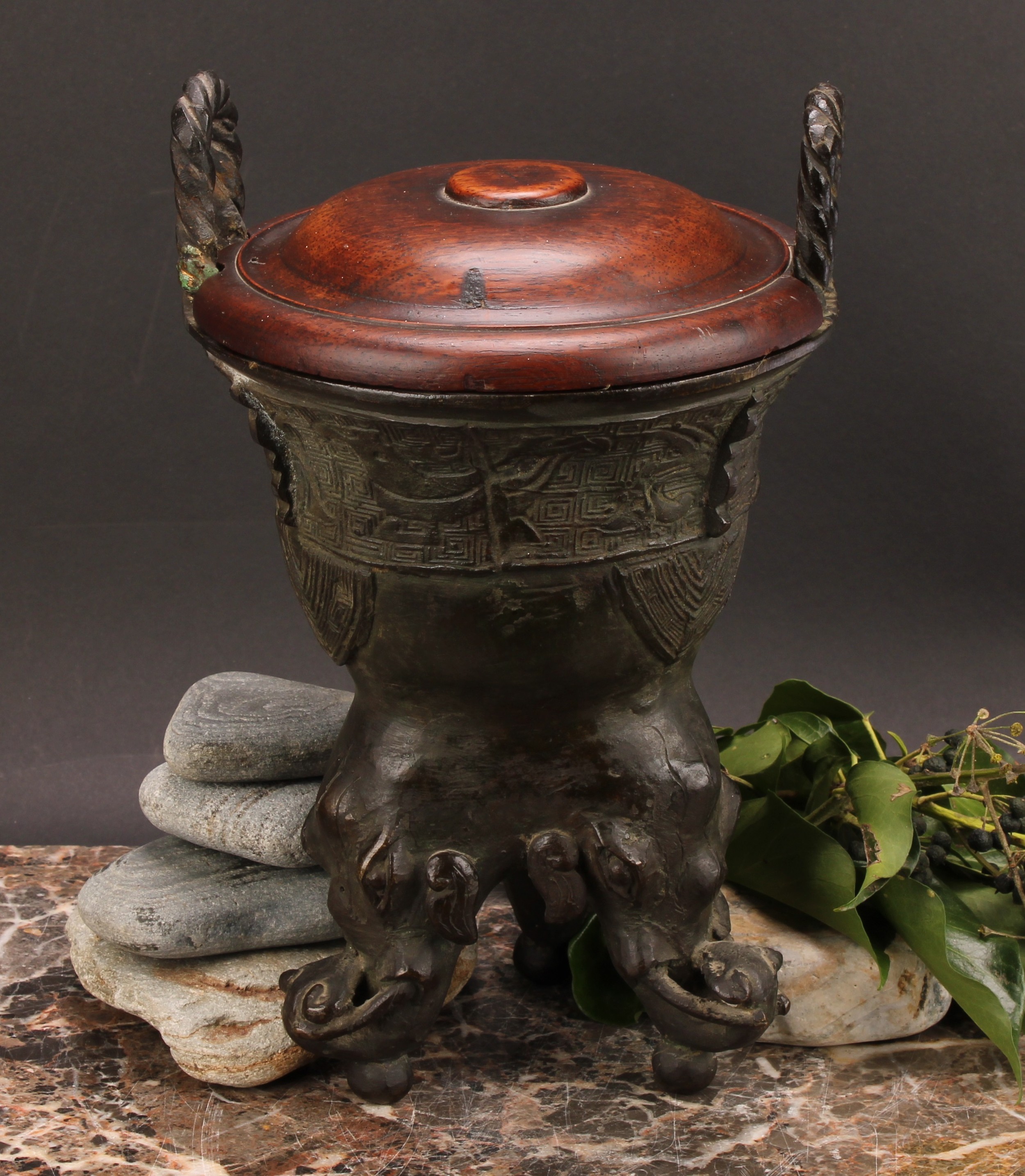 A Chinese patinated bronze ding censer, cast in the archaic manner, twist handles, outswept rim,