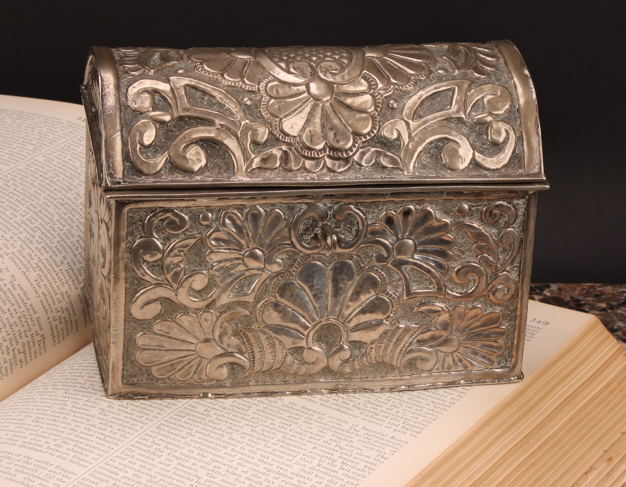 An early 20th century silver coloured metal rectangular casket, probably South American, chased with