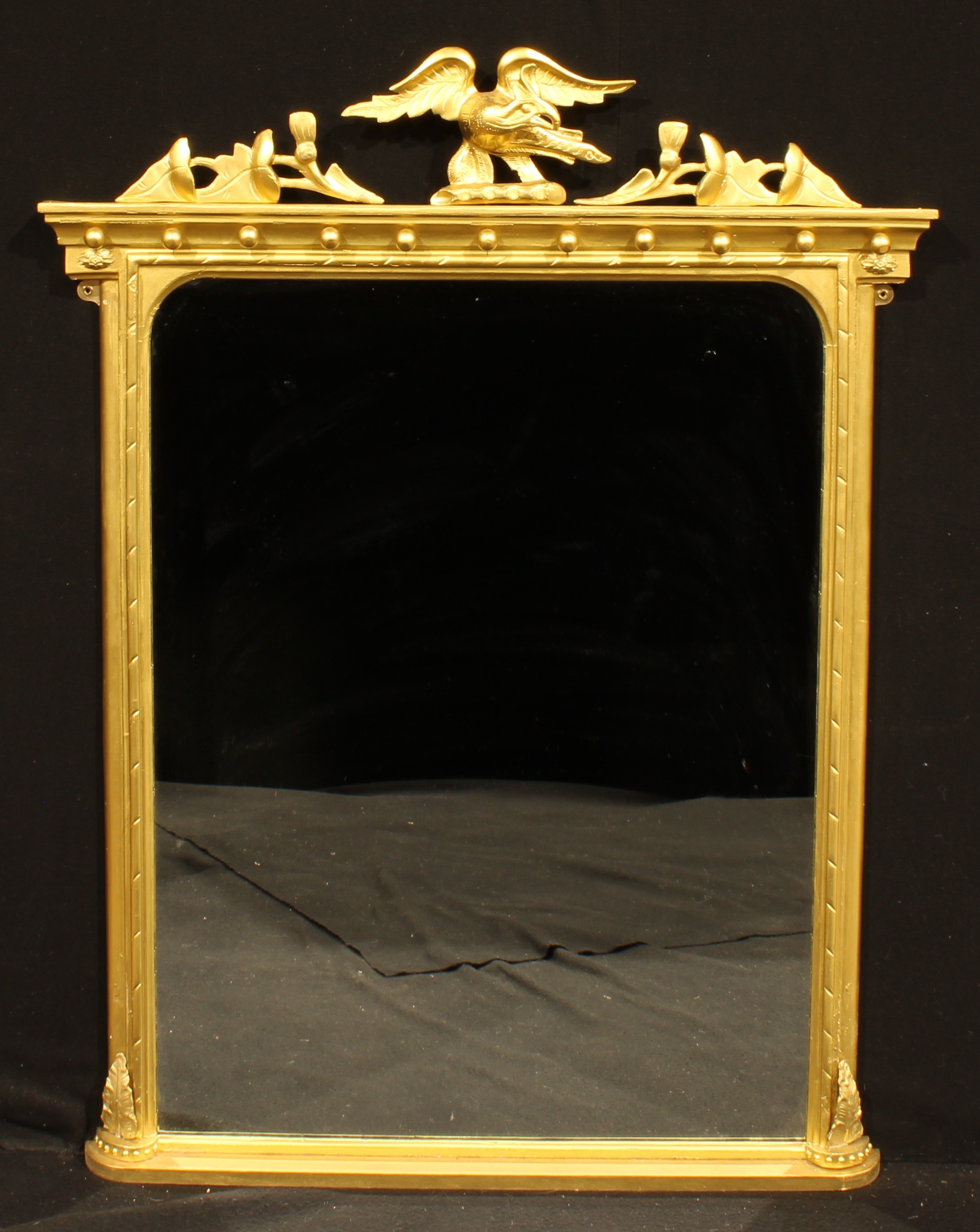 A Regency style giltwood chimney glass, rectangular mirror plate, the frame crested by an eagle,