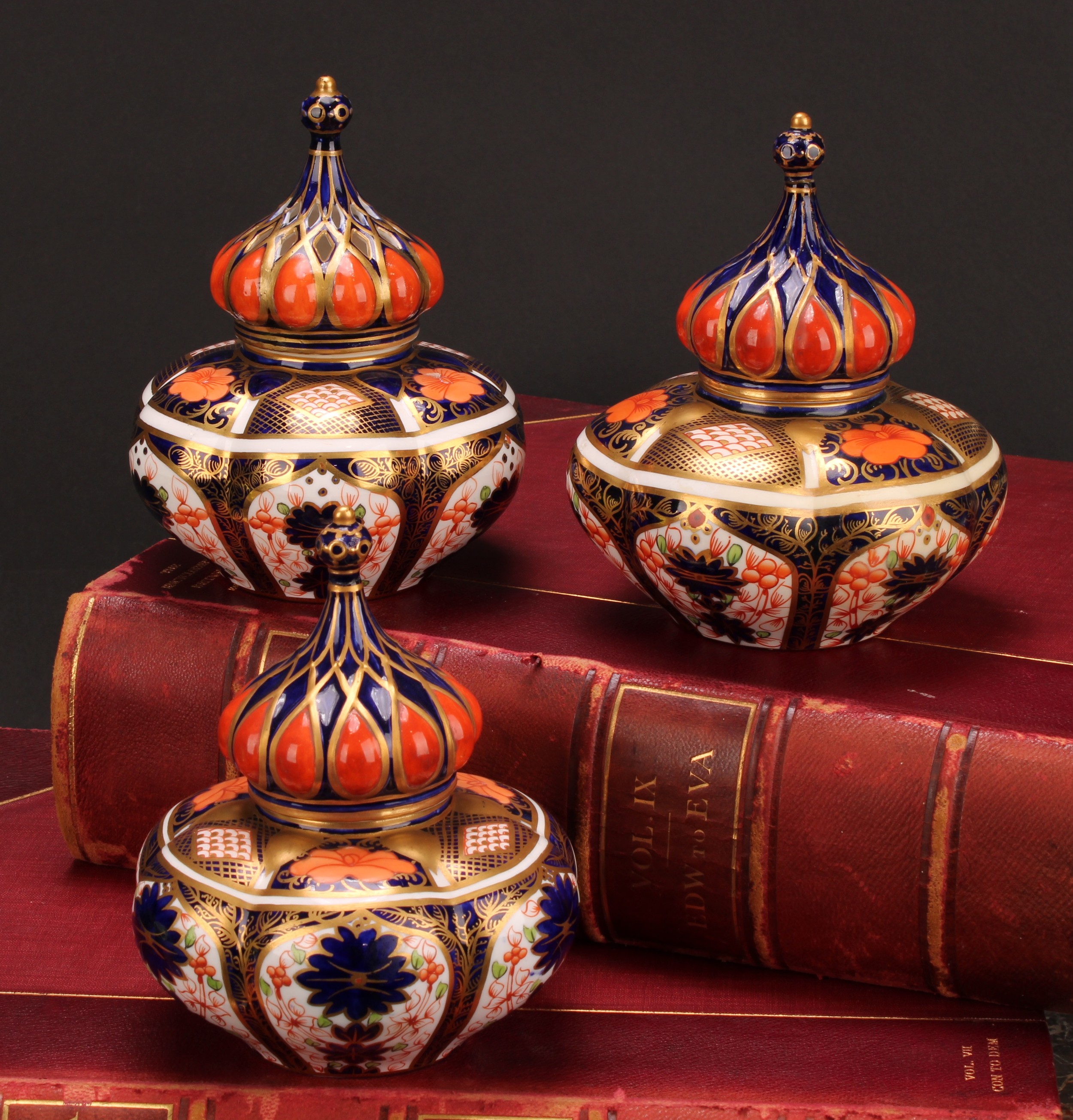 An associated pair of Royal Crown Derby 1128 Imari pattern lobed ovoid vases and covers, of