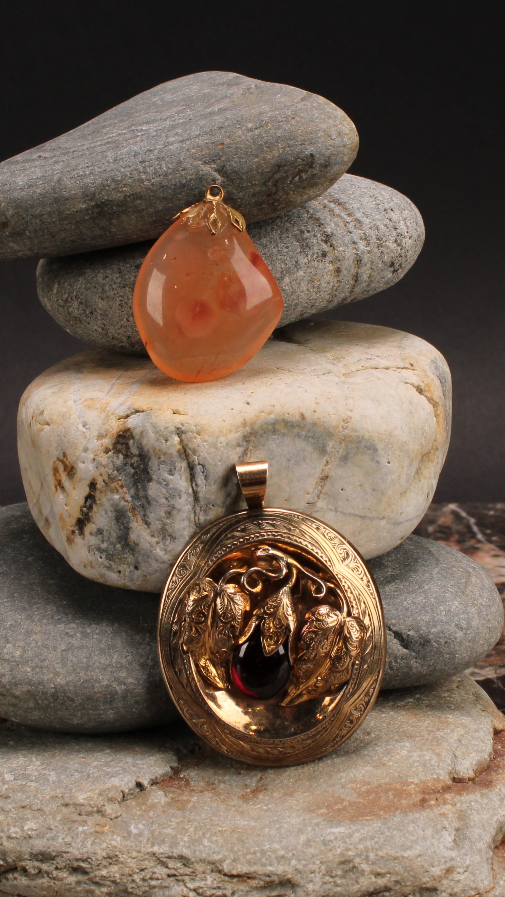A Victorian gold coloured metal oval pendant, engraved with scrolls and centred by fruiting branches