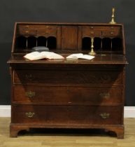 A George III oak bureau, fall front enclosing a fitted interior, above four long graduated